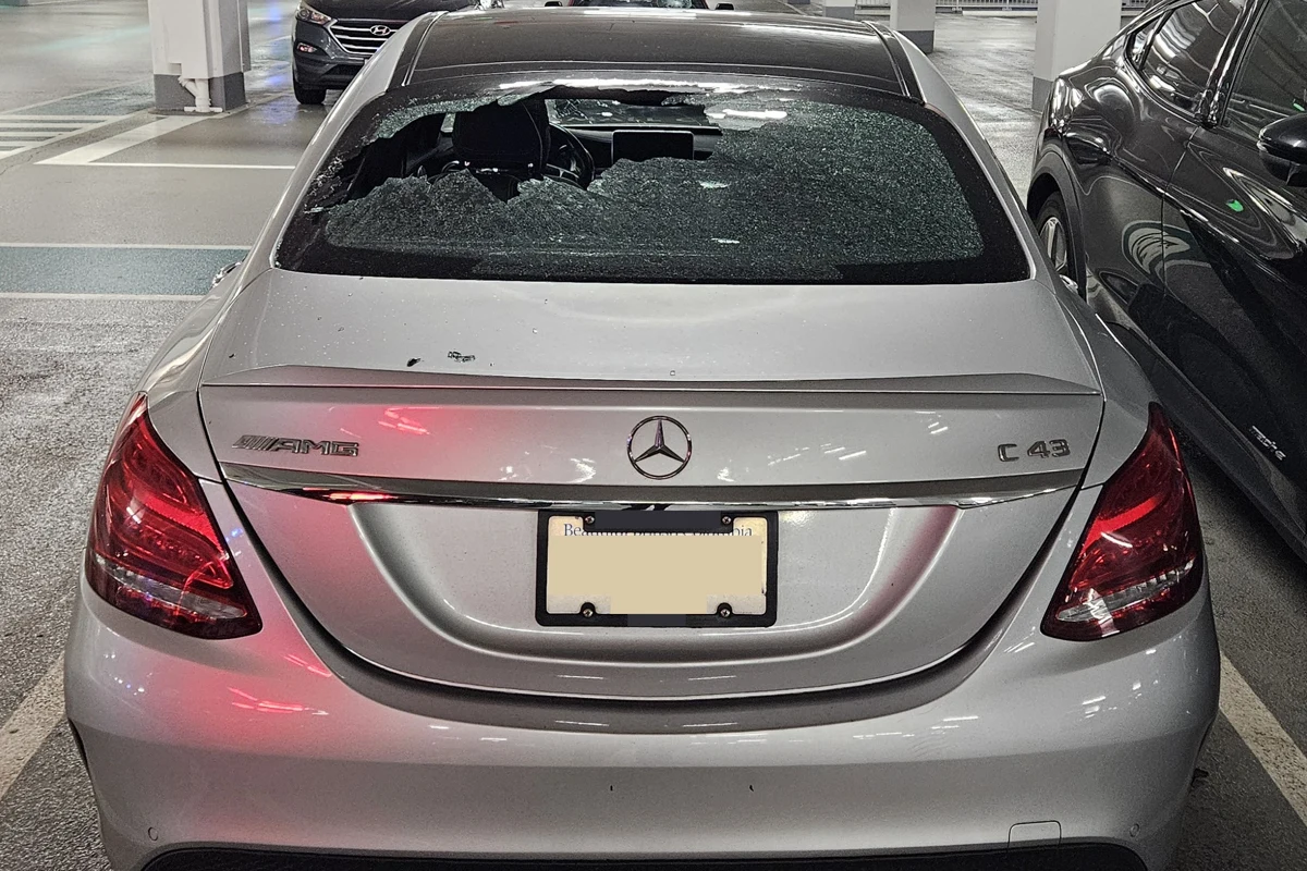 A silver Mercedes with a smashed rear window parked in the Brentwood Mall parkade