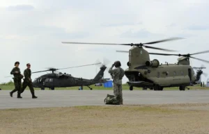 Canadian Armed Forces members walk on the tarmac at CFB Wainwright during Exercise Maple Resolve in 2013, with helicopters behind them, in a file photo