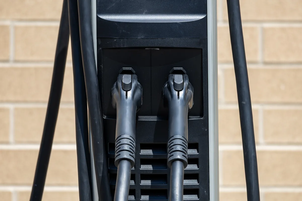 Two electric vehicle charging connectors docked at a charging station in Windsor, Ontario