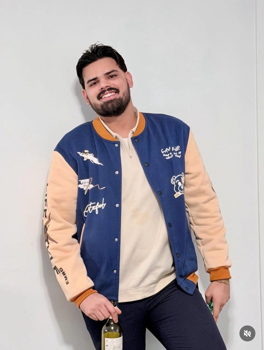 Jasdeep Singh Heir wearing a blue and tan varsity jacket