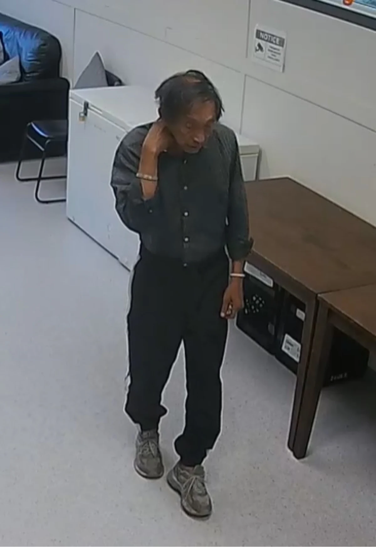Maung Maung in a surveillance image, wearing the grey button-up shirt, black pants and runners he was last seen in.