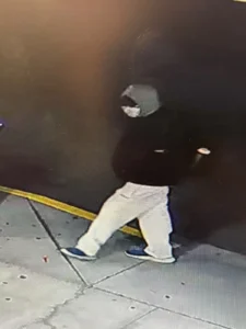 Surveillance image of a hooded suspect in light-coloured pants walking outside Country Grocer in Nanaimo
