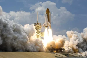 A rocket lifts off from a launch pad amid clouds of smoke and steam