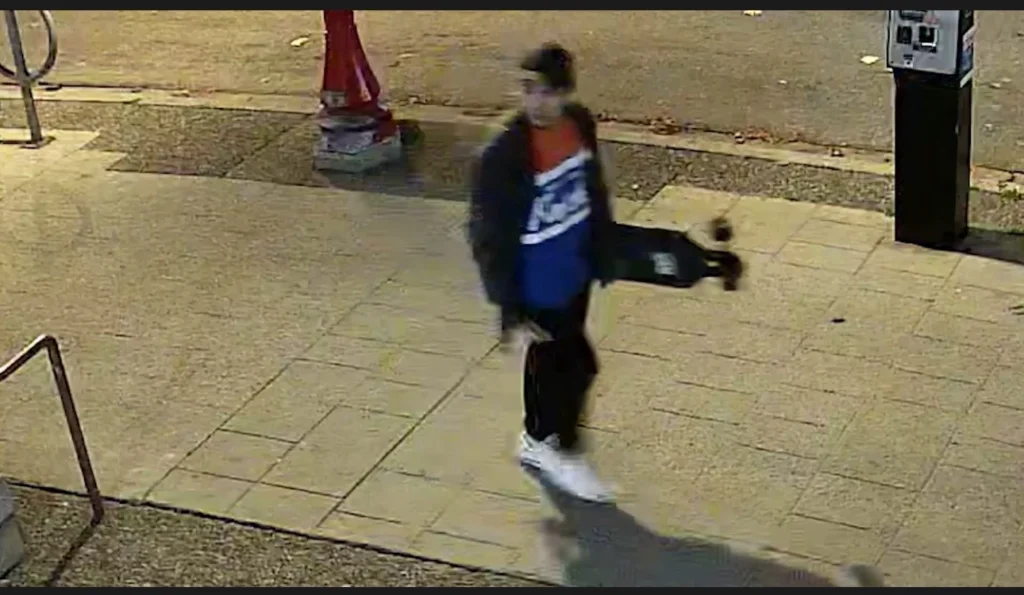 Man carrying a longboard near Columbia and Keefer streets in Vancouver, sought by VPD as a potential witness in the CRAB Park homicide